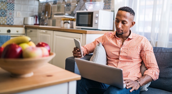 Man on computer checking his phone.