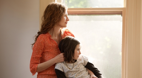 Woman and daughter looking out window.