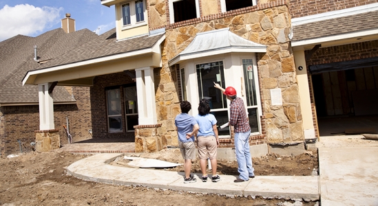 Family inspecting house being built with contractor